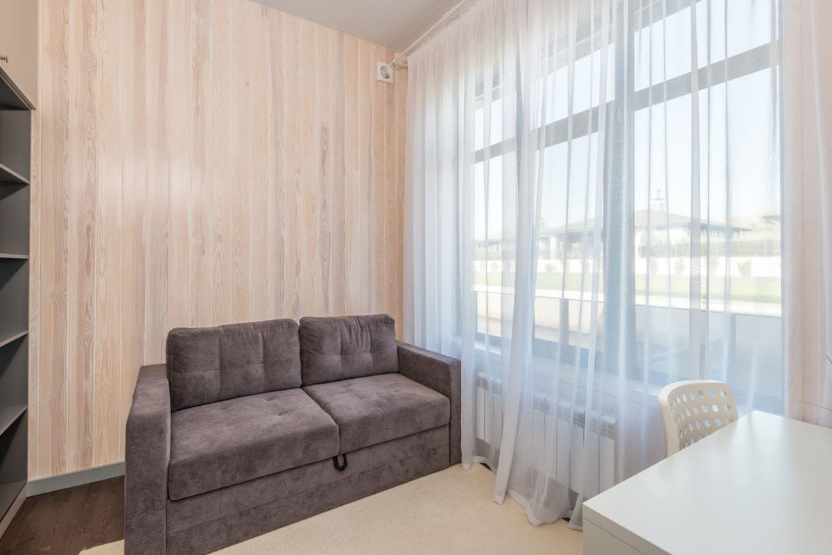 A low-profile futon-style sofa in a small, sparsely furnished room